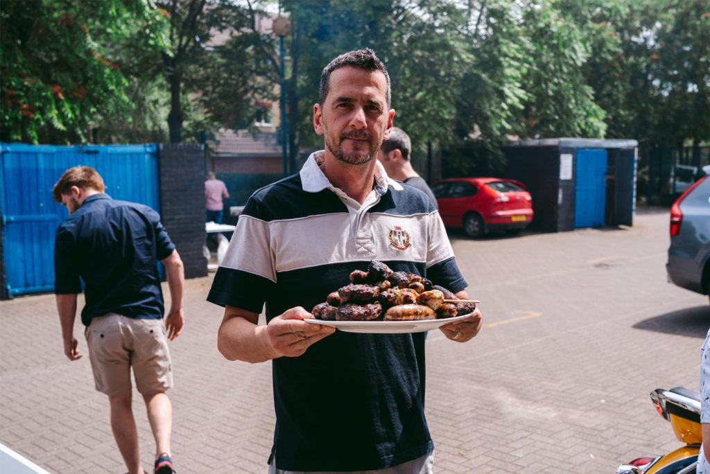 A photograph of Syrris employee, Leandro, with a plate of meat during the Syrris Summer BBQ