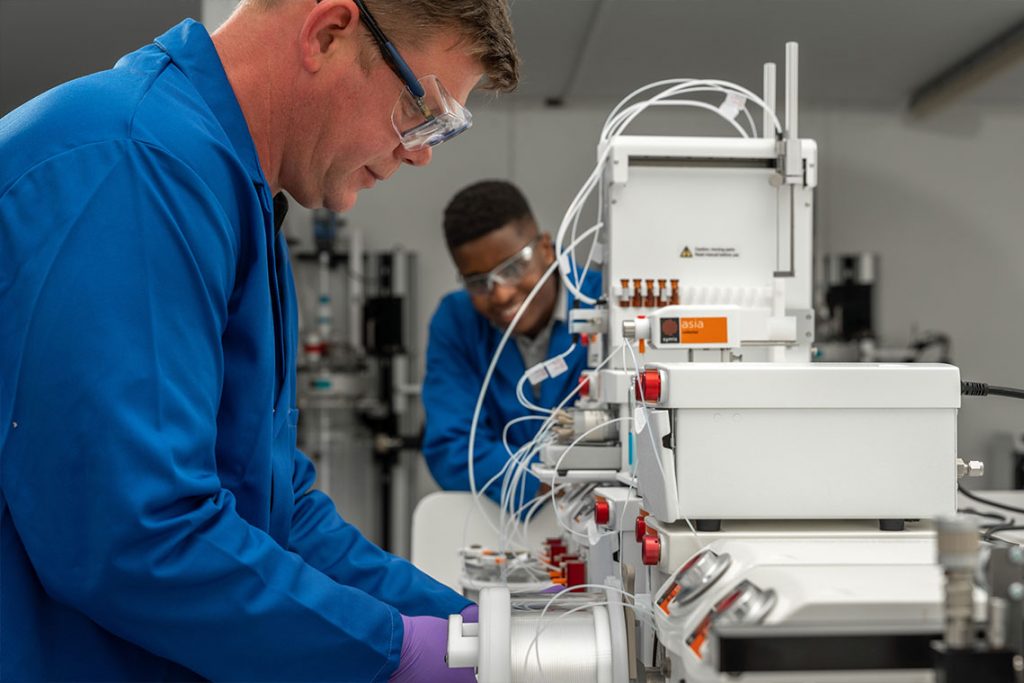 Syrris Asia, chemist in lab with tube reactor